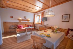 a living room with a table and a couch at Haus Alpenlicht in Reit im Winkl
