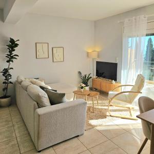 a living room with a couch and a tv at Ionelia Seaview Apartment at Barbati in Barbati