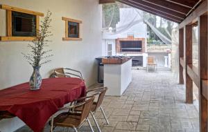 una sala da pranzo con tavolo e sedie e una cucina di Amazing Home In Macastre With Sauna a Macastre
