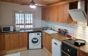 una cucina con lavatrice e lavandino di Amazing Home In Macastre With Sauna a Macastre