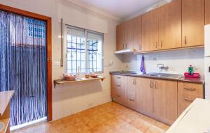 eine Küche mit Holzschränken und einem großen Fenster in der Unterkunft Nice Apartment In San Pedro Del Pinatar in San Pedro del Pinatar