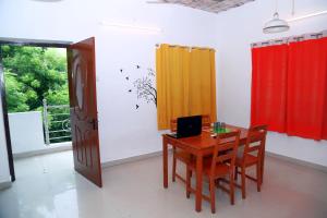 a dining room with a table with a laptop on it at Urban Elite Home Stay in Puducherry