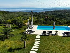 a view of a swimming pool on a hill with chairs at Apartmaji Meli Pu in Izola