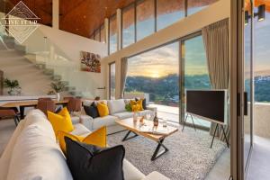 a living room with a couch and a tv at Santi Peak Villas in Amphoe Koh Samui