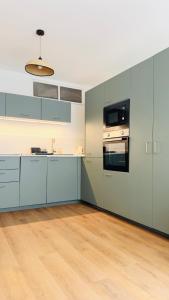 een keuken met blauwe kasten en een houten vloer bij Appartement Chic 50m de la mer in Palavas-les-Flots