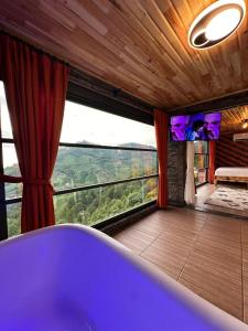 a bath tub in a room with a large window at Oksijen Suit in Çamurlu