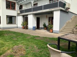 a white building with stairs and a table in a yard at Ferienhaus Brenda in Schillingsfürst