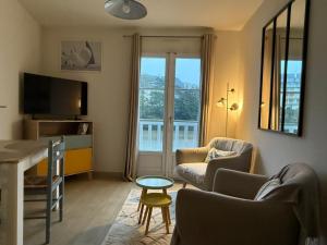 salon z kanapą, 2 krzesłami i telewizorem w obiekcie Appartement T2 vue sur la rivière avec garage privatif - Port de Saint-Goustan w mieście Auray