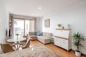 un soggiorno con un divano e un tavolo di FiveStepsToSea - Beach Apartment Valencia a Valencia