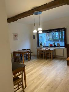 ein Wohnzimmer mit Tischen und Stühlen und eine Küche in der Unterkunft Guanto vakantiewoning in Ronse