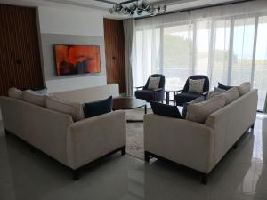 a living room with two couches and chairs at Beach Breeze 001 in Mombasa +20 photos