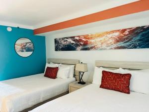 two beds in a room with blue and orange walls at 453 Shore Fun Oceanfront Great Location in Myrtle Beach +51 photos