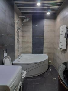 a bathroom with a bath tub and a sink at Tatapartment in Tbilisi City