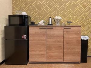 a kitchen with a microwave and a refrigerator at 藤通天阁景观民宿 in Osaka