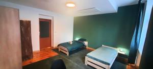 Un dormitorio con dos camas y una pared verde. en Stacja Jeżyce, en Poznan