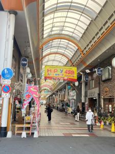 大阪市にあるSHINSEKI 303 NEW OPen 割引あり 千鳥橋駅徒歩8分 USJまで近い 難波まで電車11分 2LDK広いリービングの人が歩くショッピングモール