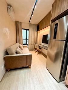 a living room with a couch and a refrigerator at Essential 2U in Sao Paulo