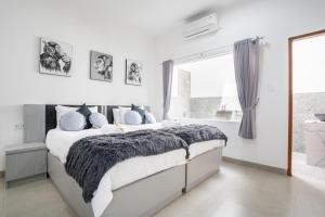 ein weißes Schlafzimmer mit einem großen Bett und einem Fenster in der Unterkunft Aster Villa by iBali Management in Legian + 53 Fotos
