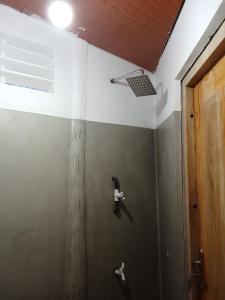 a bathroom with a wall with a door and a ceiling at Holiday Beach Cottage in Ahangama