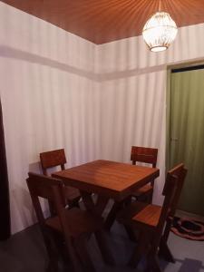 a dining room with a wooden table and chairs at Holiday Beach Cottage in Ahangama