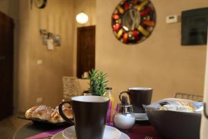 a table with two cups and a plate of food at Le Stanze d'Ercole in Tivoli