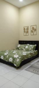 a bedroom with a bed with a green comforter at D'Z Homestay Jejawi Perlis in Kangar +5 photos