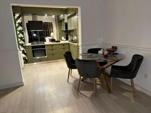 a kitchen with a table and chairs in a room at Boutique apartment in Ploieşti