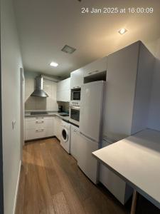 a kitchen with white appliances and a table in it at Principal Plaza in Salamanca