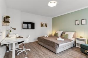 a bedroom with a bed and a desk and a computer at SHINY HOMES - Trendy Apartment Close to City Center in Bielefeld