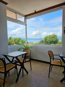 balcone con tavoli, sedie e vista sull'oceano di Adlaw Inn a Città di Puerto Princesa