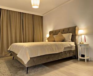a bedroom with a large bed with a large headboard at Boutique apartment in Ploieşti