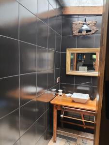 a bathroom with a wooden table and a mirror at El Tambucho Miramar BsAs in Miramar