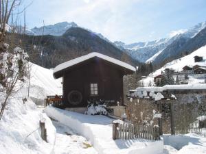 ein kleines Haus im Schnee mit einem Zaun in der Unterkunft Ferienhaus Wassermühle in Maria Luggau