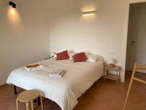 a bedroom with a large white bed with red pillows at Appartamento Pitosforo e Camera Melograno in Leivi