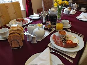 uma mesa com pratos de comida para o pequeno almoço em The Old Vicarage em St Austell