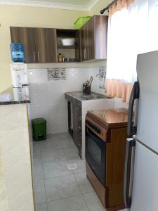 a kitchen with a refrigerator and a stove top oven at Nest and key in Nguluni