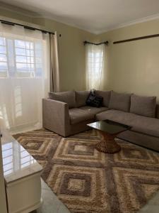 a living room with a couch and a table at Nest and key in Nguluni