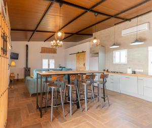 una cucina con bancone con sgabelli e divano di La Platea Rural a Siviglia
