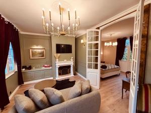 Una sala de estar con un sofá y una chimenea. en La Suite, en Étretat