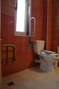 ギリキにあるGlykis Earの赤いタイル張りのバスルーム(トイレ、窓付)
