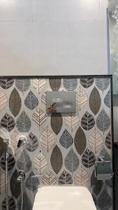 y baño con pared de baldosa y lavabo. en Millennium Suites - Comfy King- Twin Room, en Orchha