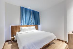 a bedroom with a white bed and a blue window at UNO Express Asoke Sukhumvit Bangkok in Bangkok +67 photos