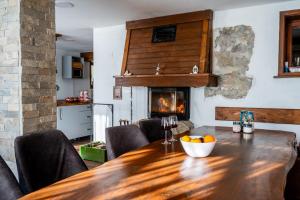 ein Esszimmer mit Tisch und Kamin in der Unterkunft Къща за гости Приказка in Klisura