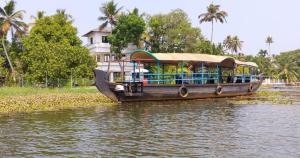 a boat on the water with people on it at The Riverview Residency-Waterfront Pool Villa,Chirayam, Ernakulam in Ernakulam +4 photos