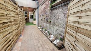 un callejón con una pared de ladrillo con plantas. en Appart Cosy avec SPA privatif proximité Lille, Le Chalet, en La Bassée