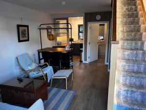 ein Wohnzimmer mit Stühlen, einem Tisch und einer Treppe in der Unterkunft Bath Lane Cottages & Sauna Garden x8 beds in Newcastle