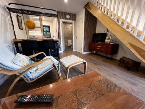 ein Wohnzimmer mit einem Stuhl, einem Tisch und einer Treppe in der Unterkunft Bath Lane Cottages & Sauna Garden x8 beds in Newcastle