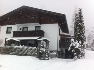 a house covered in snow with a christmas tree at Haus Obertiefenbach in Radstadt