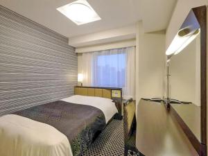Postel nebo postele na pokoji v ubytování APA Hotel Namba Ekihigashi