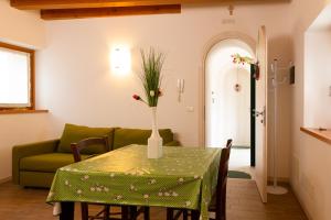a living room with a table and a green couch at Albergo Diffuso Polcenigo C. Zoldan in Polcenigo